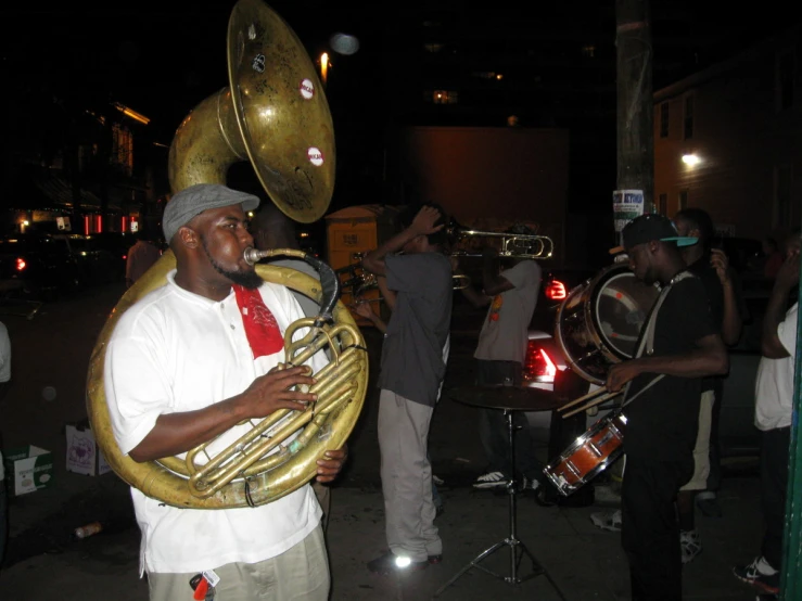 a man in hat and tie playing the trombone