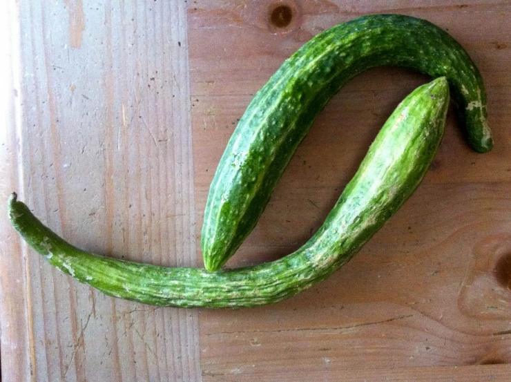 a cucumber on top of wooden planks with eyes drawn