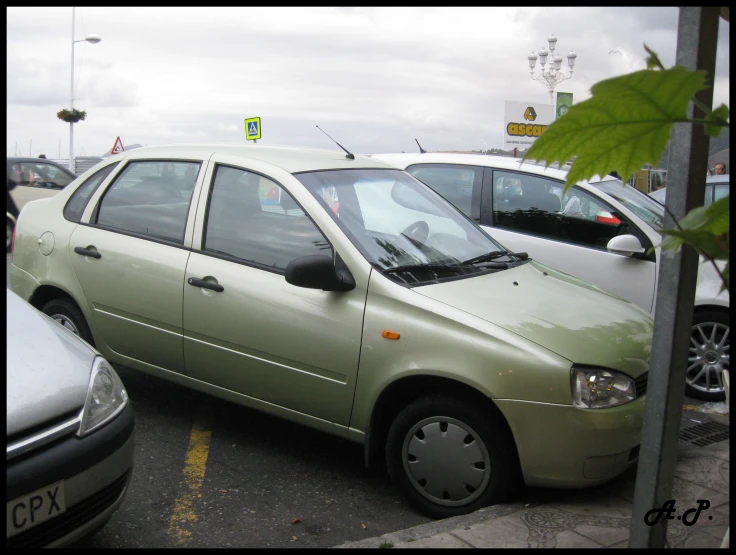 small, pale colored car parked in a parking lot