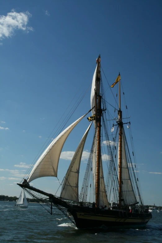 an old fashioned sailing boat with large sail