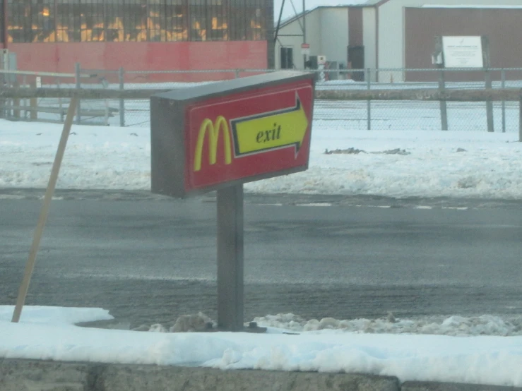 a mcdonald's sign on the side of a snowy street