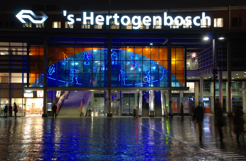 the entrance to a shopping mall in germany is lit up at night