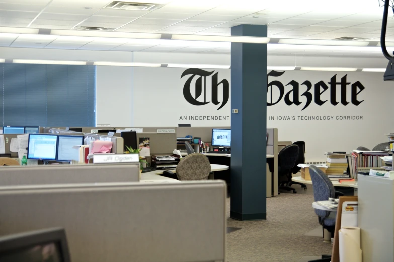 an open office with several computer screens and a large logo