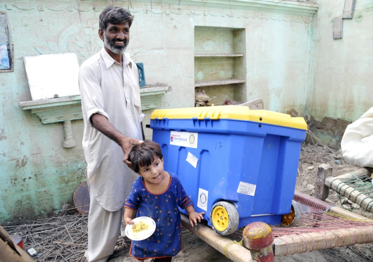 a man and a child with a trashcan on the ground