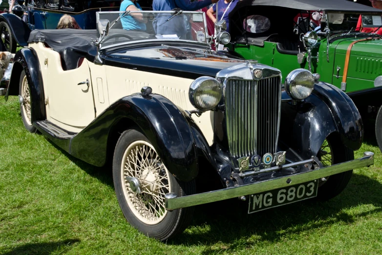 antique vehicles are parked on grass at a car show