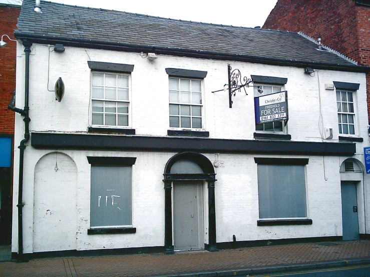 two buildings side by side with an awning and sign in the window