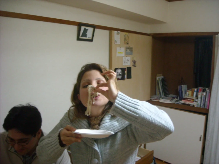 a woman is holding a plate with a piece of food on it