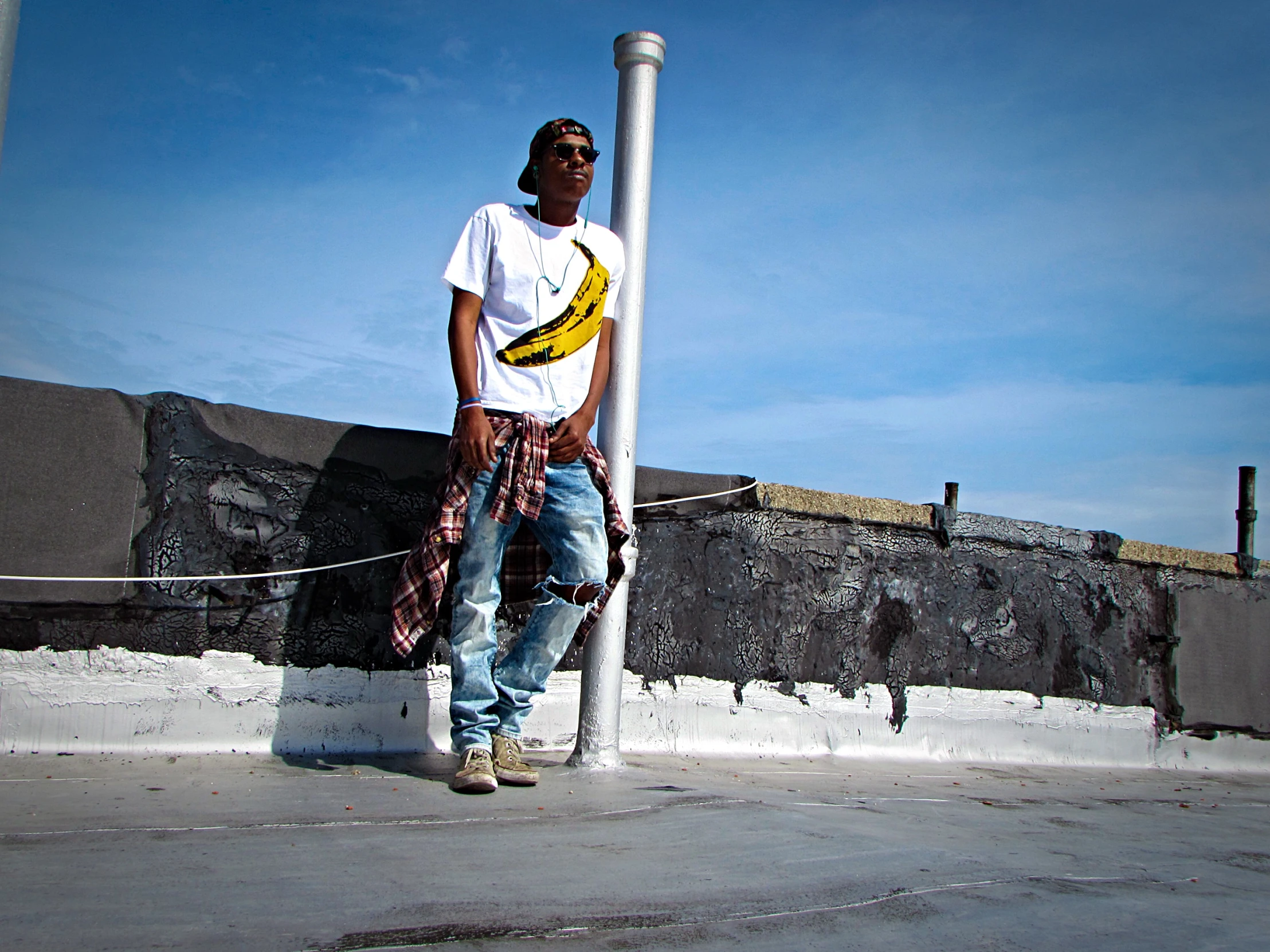 a man standing next to a pole with a banana on it