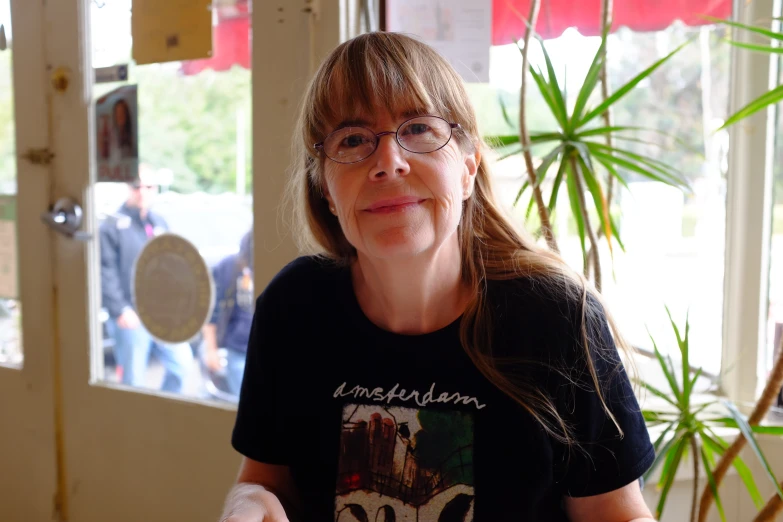 a woman with glasses on her shirt and holding a fork in front of a door
