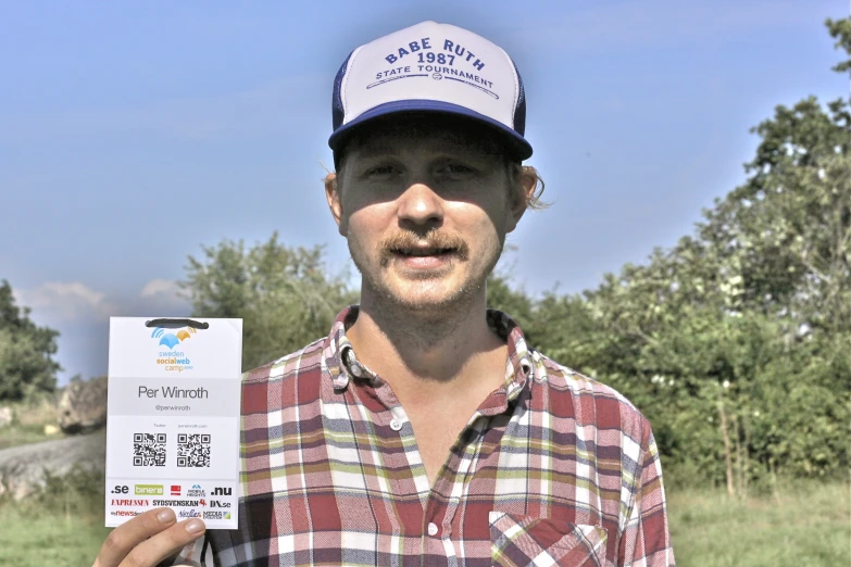 a man wearing a plaid shirt holding a small package