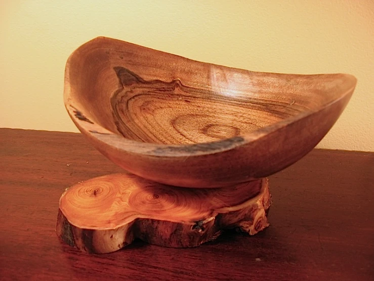 a wooden bowl sitting on top of a log