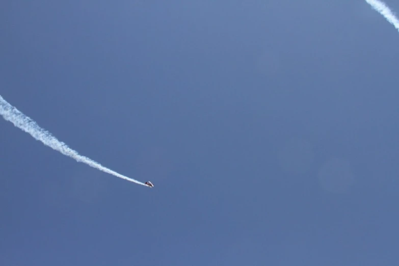 two jets flying through the sky leaving trails in the air