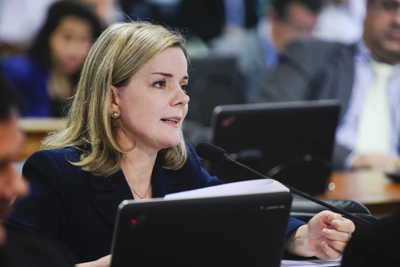 a woman sitting at a table with a laptop