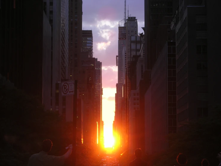 the sun rising over a crowded city street in the city