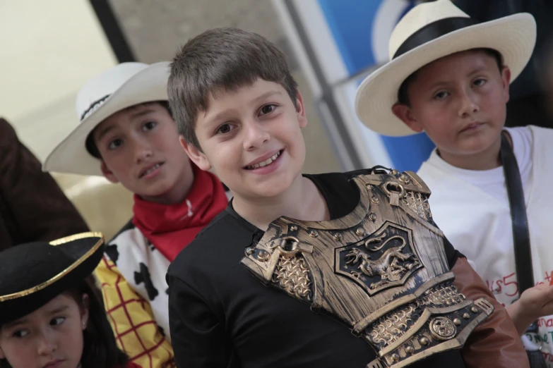 several young children standing wearing different hats