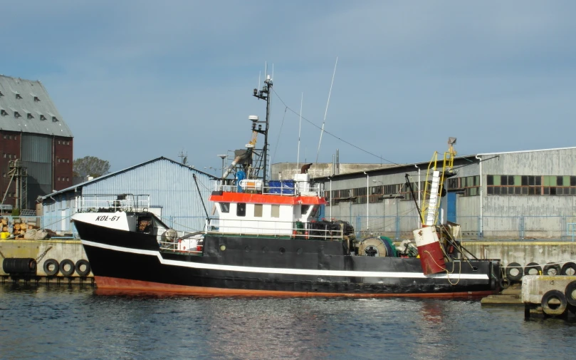 a black and white boat docked at a dock