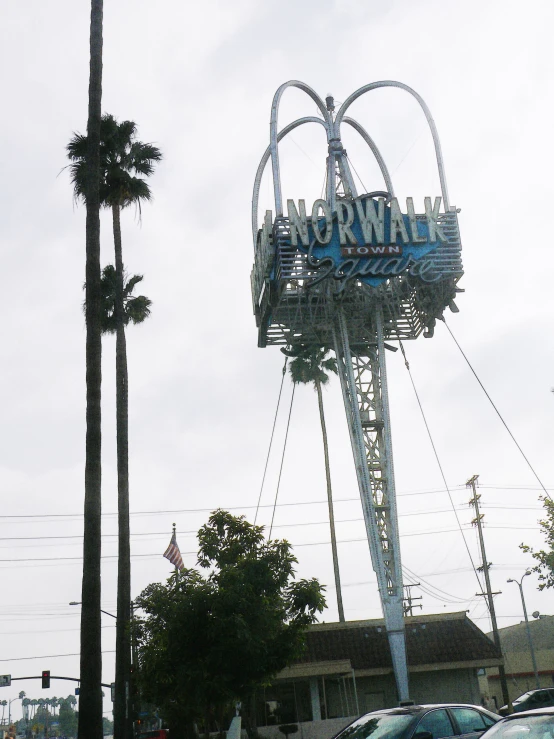 the ferris wheel is very tall with cars parked below it