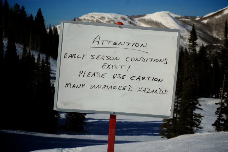 a snow covered mountain is seen behind a sign