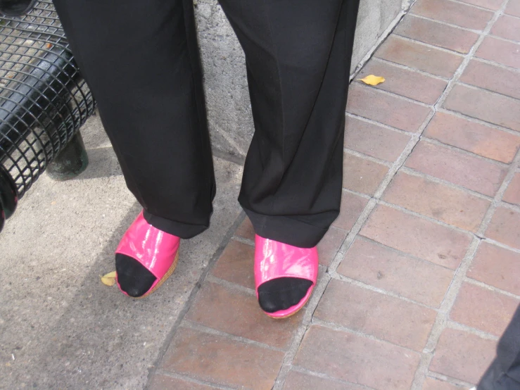 woman in black and pink shoes standing on sidewalk