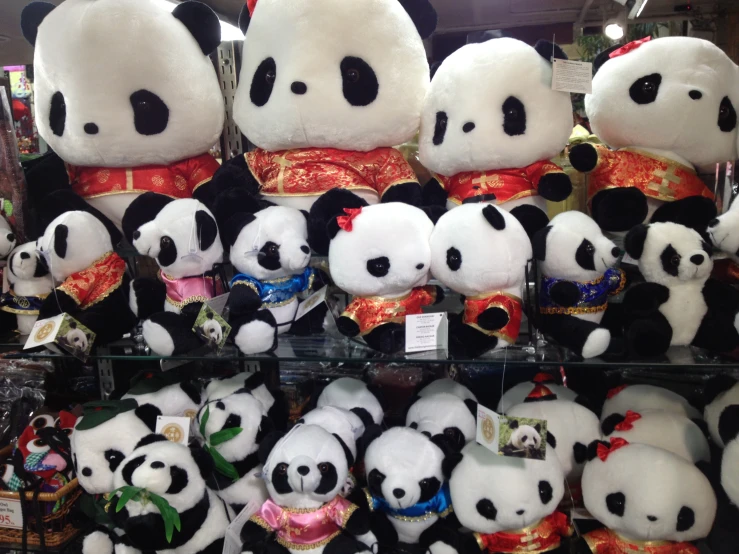 many stuffed pandas and other stuffed animals are on display