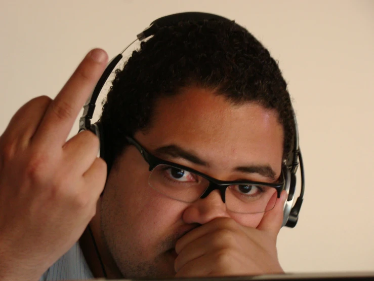 a man wearing headphones and holding his thumb up