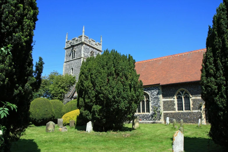 an old church with a tower surrounded by trees