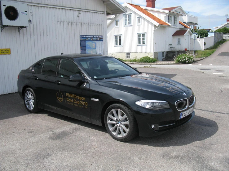 a bmw car with a business sign on the side of it