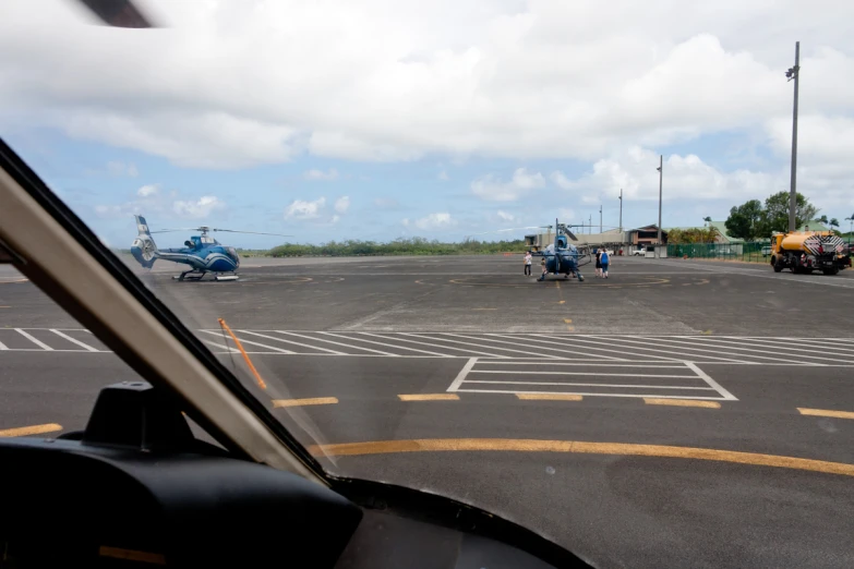 a couple of men walking towards a helicopter in the air