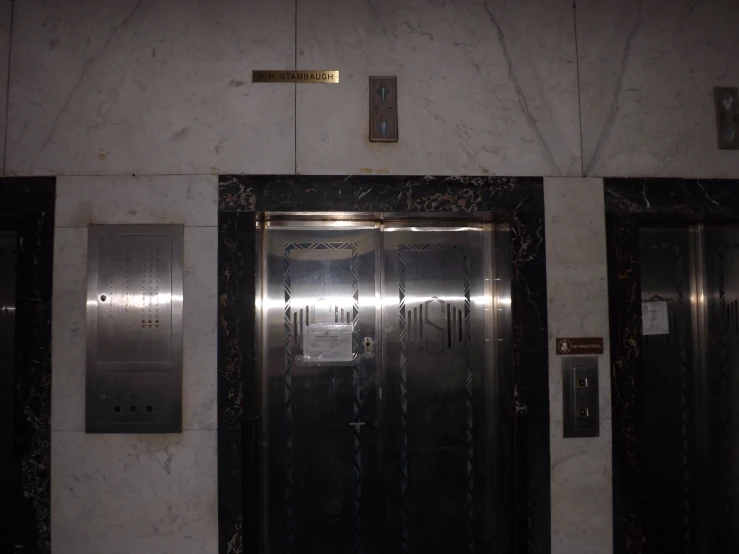 an elevator in the center of two very tall doors