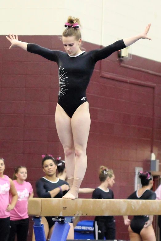 a girl on a beam is doing gymnastics