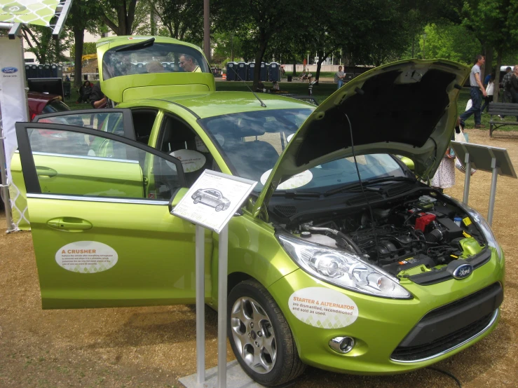a green ford fiesta with its hood open