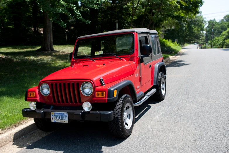 a red jeep parked in front of a house