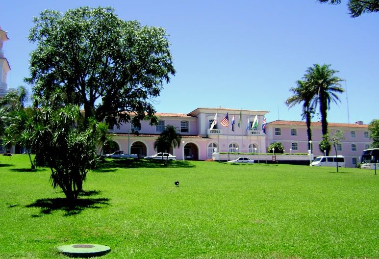 a green field and several buildings on the other side