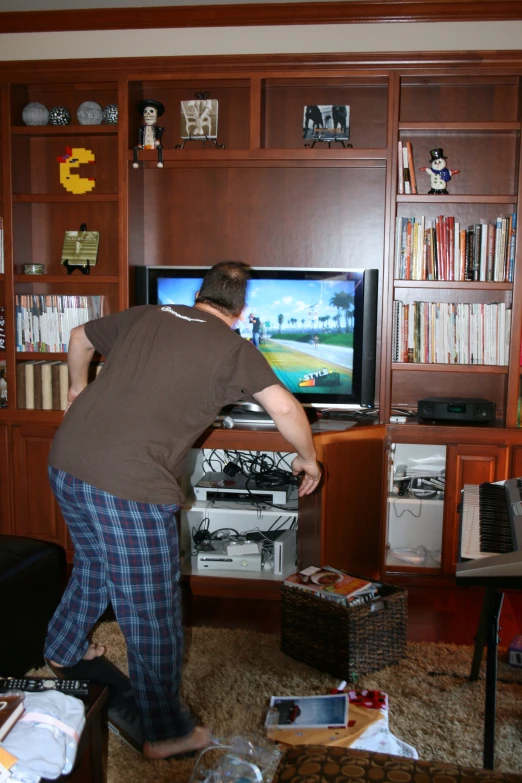 a man standing in a living room playing a video game