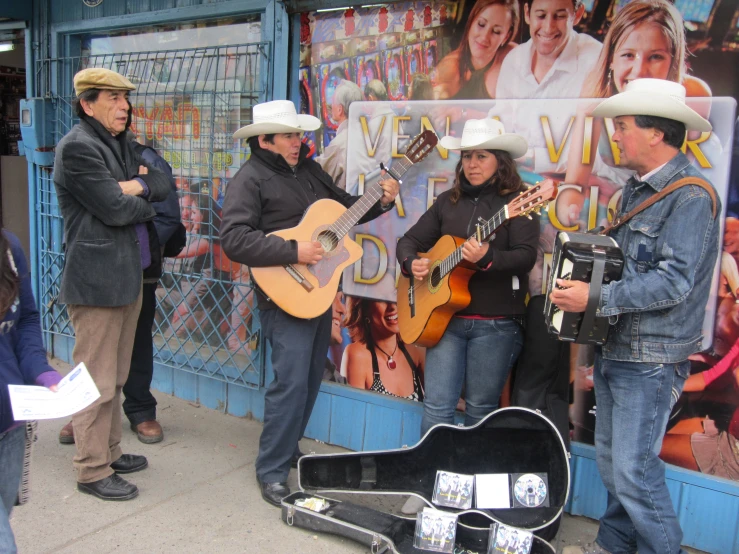 a group of people are outside playing guitar and singing