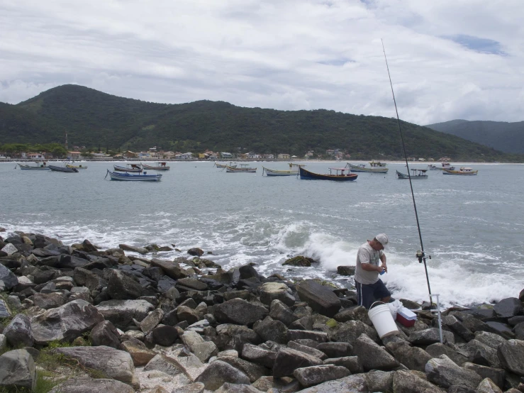 two men are fishing on the shoreline of the ocean