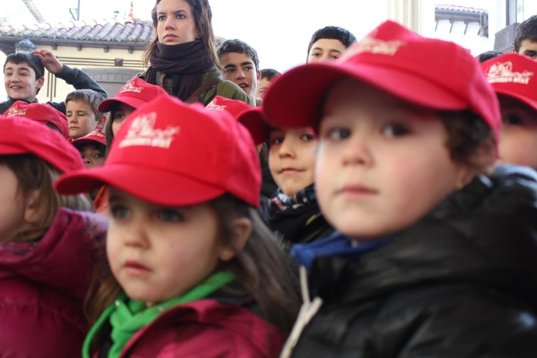 a group of people with red hats and one woman in the background