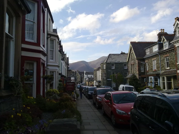 parked cars lined up in front of some brown and white houses