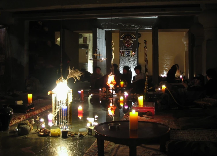 a group of people standing next to each other in front of a building with candles