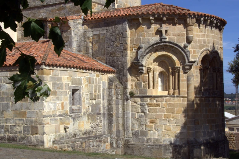 an old stone building with a red tiled roof