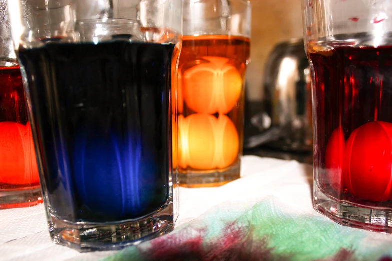 four different types of liquid in vases on a table