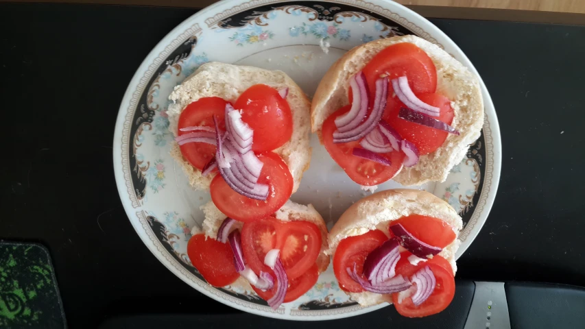 a plate with  dogs covered in toppings