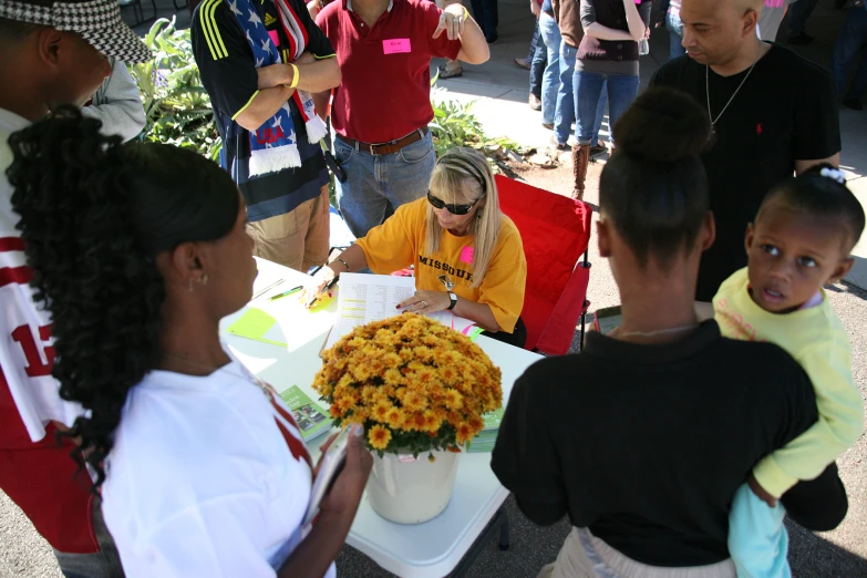 a group of people looking at some yellow flowers