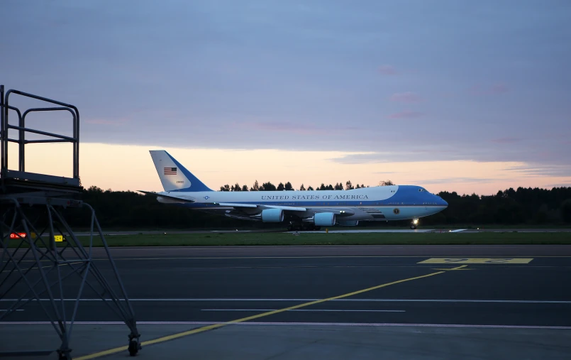 a jet on the runway next to a truck