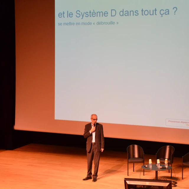 a man is standing on the stage and giving a lecture