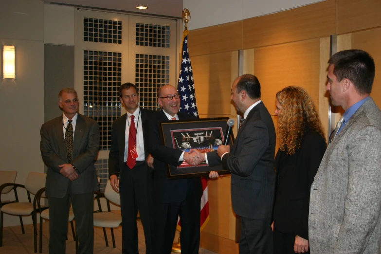 four people are gathered together and three have signed books of presidents