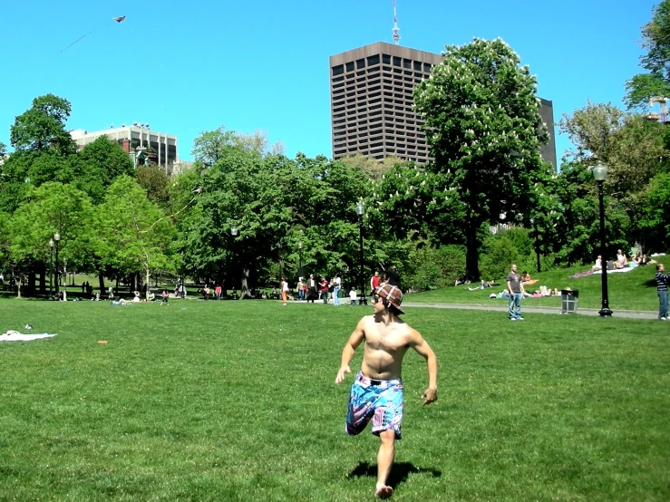 a man runs in the grass while holding a kite