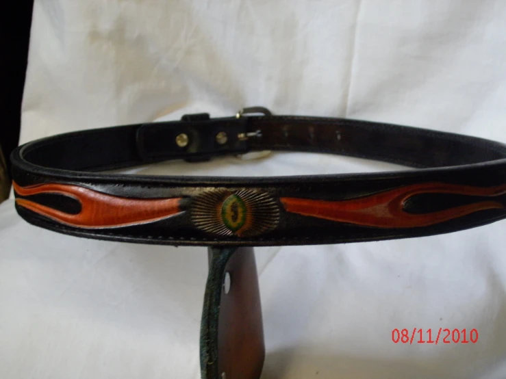 a black belt with orange flames and a circle decoration
