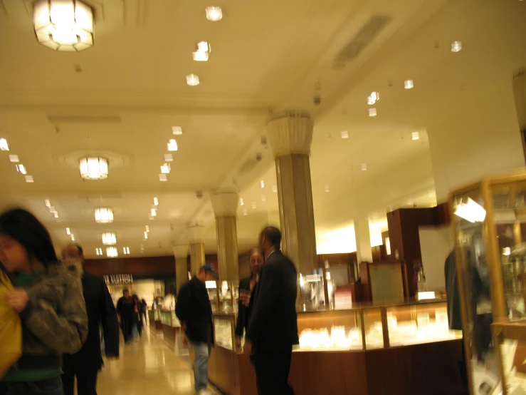 people are walking through a large store with chandelier