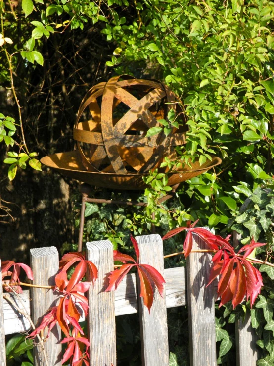 the wooden fence in front of the fence is holding an interesting sculpture